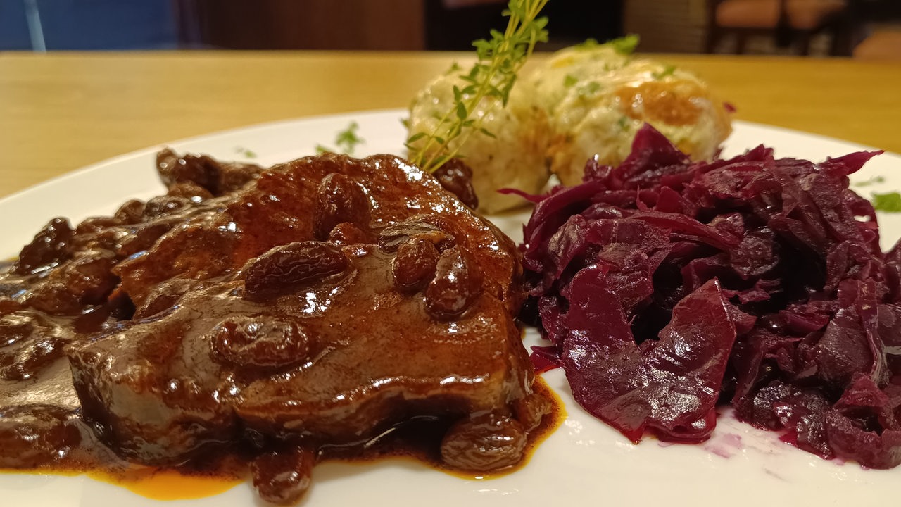 Sauerbraten, Rotkohl und Klöße auf einem Teller