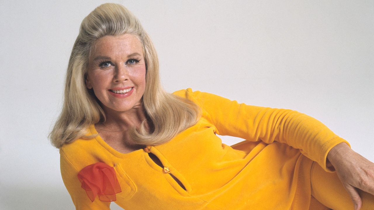 Die amerikanische Schauspielerin Doris Day (bürgerlich Doris von Kappelhoff) posiert liegend in einem kanariengelben Zweiteiler.